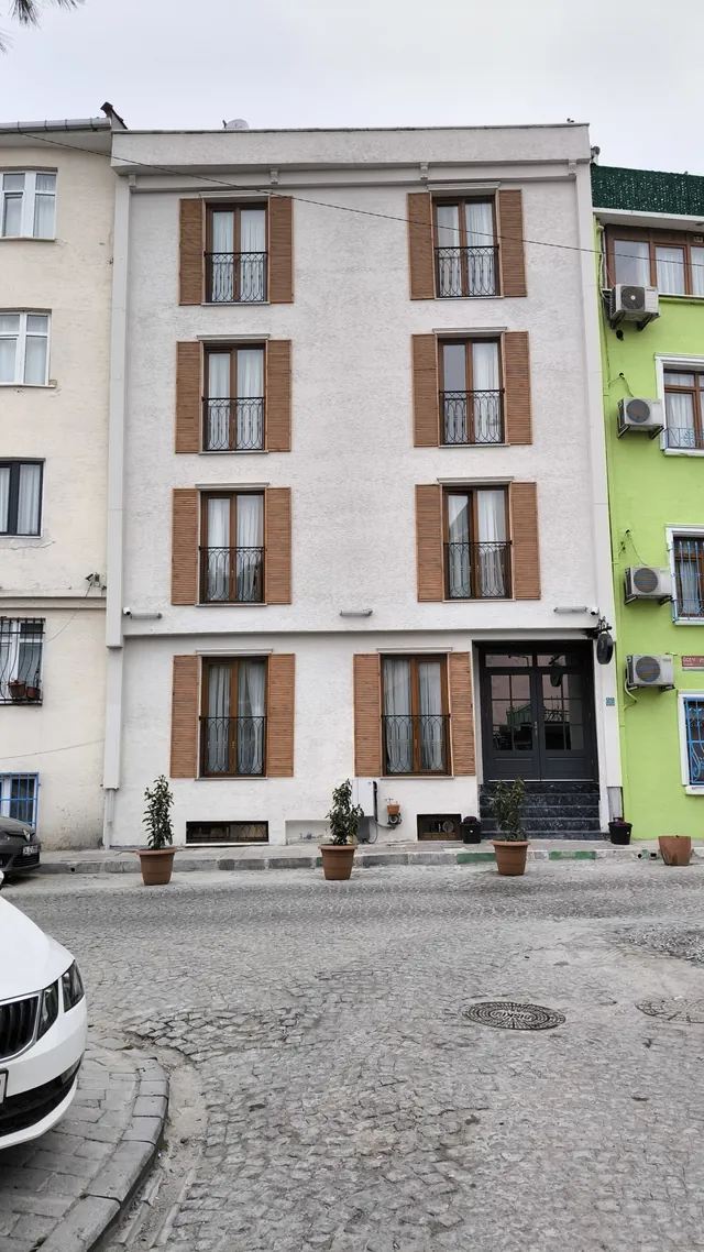 Otelin beyaz cephesi ve arnavut kaldırımlı sokak
