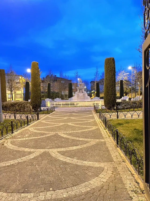 Alacakaranlıkta fıskiyeli parkın taş yolu