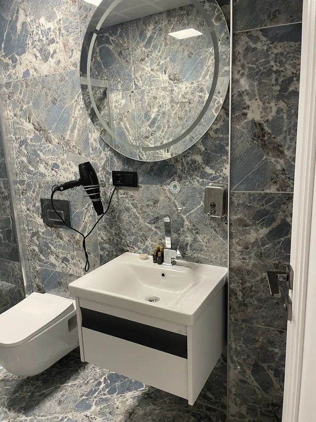 Yuvarlak aynalı mermer banyo