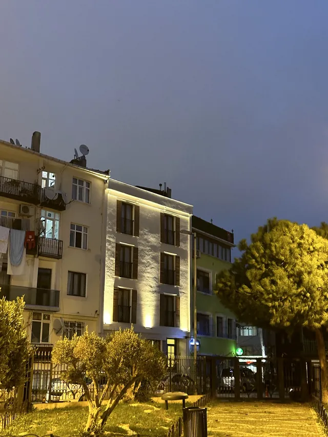 Bahçe ve ağaçlar arasından otelin gece görünümü